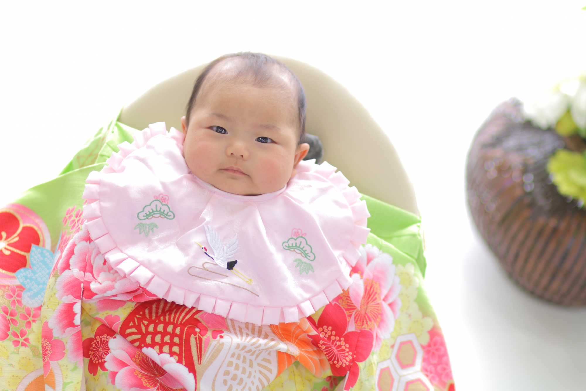 写真：お宮参りの赤い産着の赤ちゃん