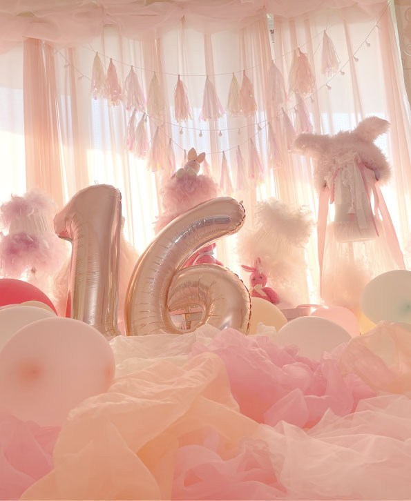 写真：16をイメージした風船のあるピンクの部屋