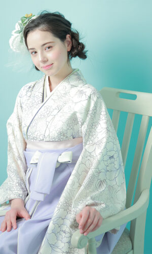 写真：白い着物と薄紫の袴を着て撮影する女性