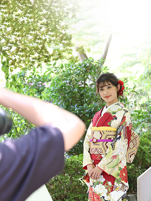 写真：撮影される赤い振袖姿の女性