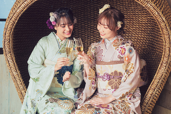 写真：お酒のあるパーティー会場にいる振袖の女性