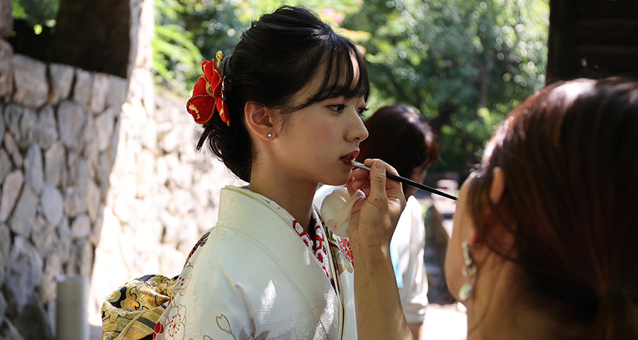画像：ロケーション撮影中の化粧をされている白い振袖の女性