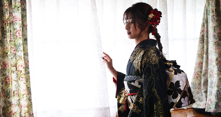 画像：スタジオで撮影中の黒い振袖の女性